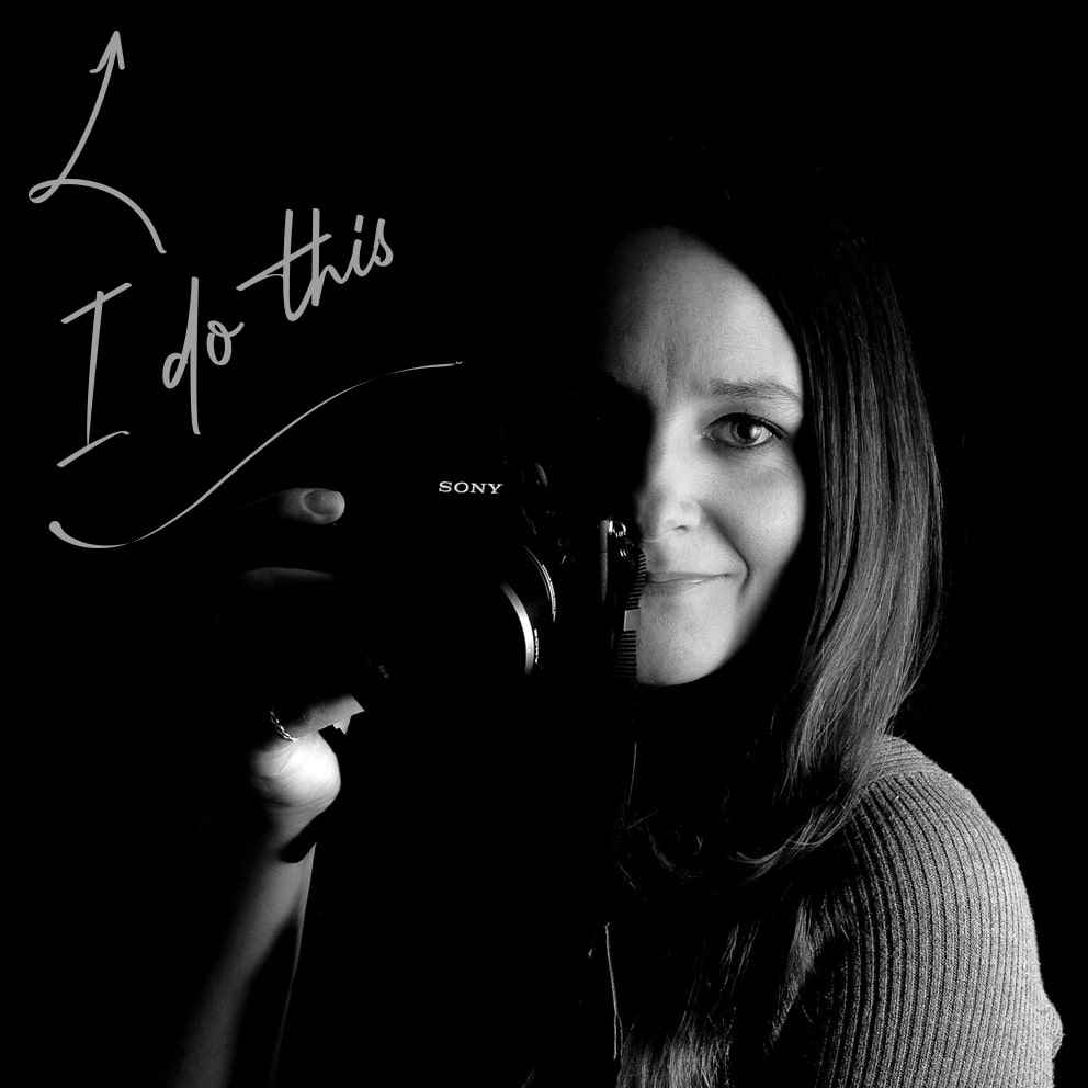 Black & white profile picture of Emma Seaney, an award-winning photographer from Hampshire. Holding her Sony DSLR camera.